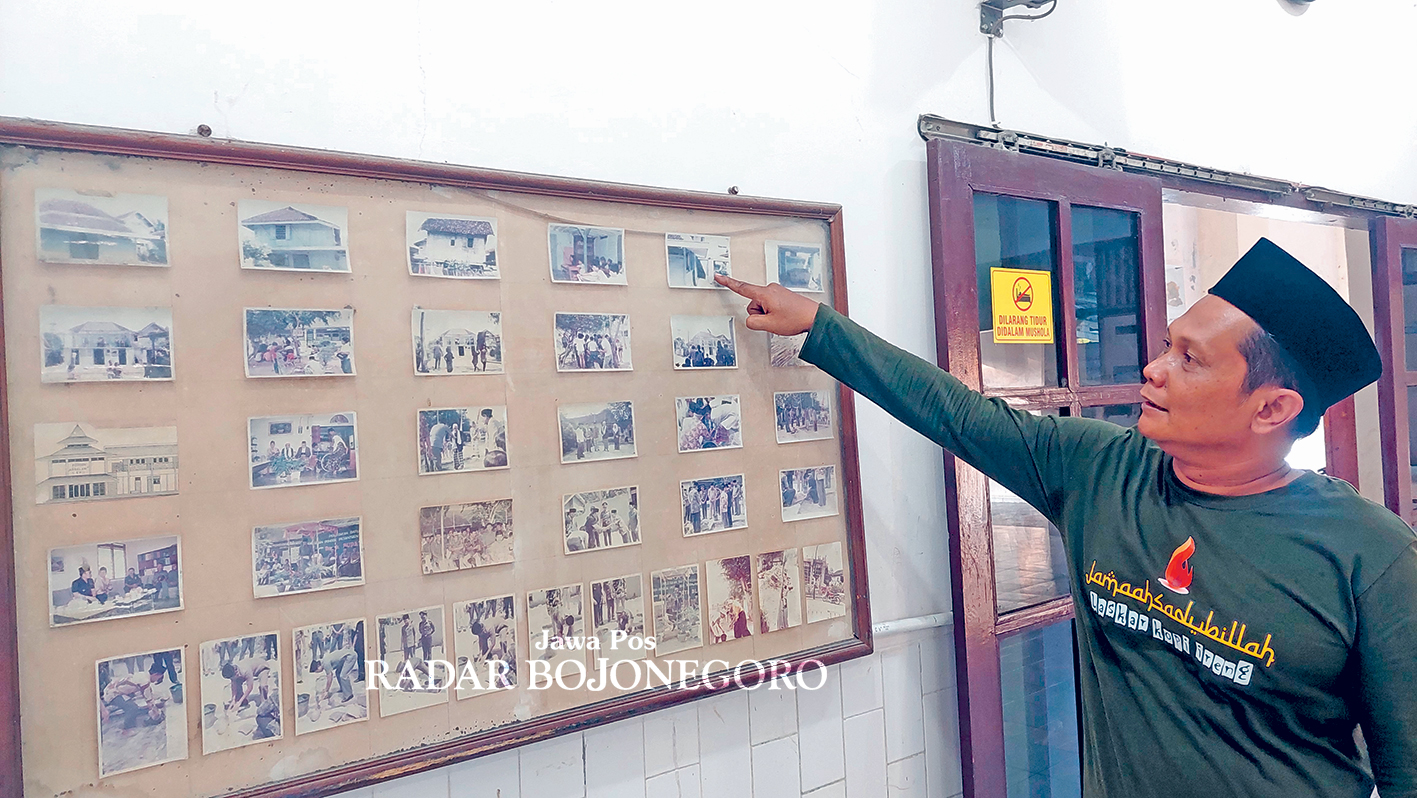 MEMORI: Kiai Arief Usman memperlihatkan foto-foto arsip tertempel rapi di dinding musala Ponpes Assalam. (LUKMAN HAKIM/RADAR BLORA)