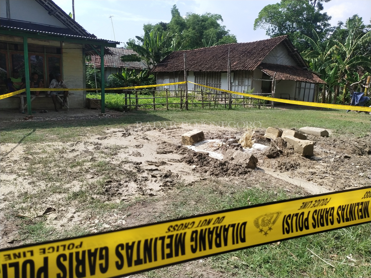 DIGARIS POLISI: Semburan lumpur berbau belerang di Desa Sidomulyo, Kecamatan Kedungadem kemarin (26/12) diberi garis polisi. (NURCOLIS/RADAR BOJONEGORO)