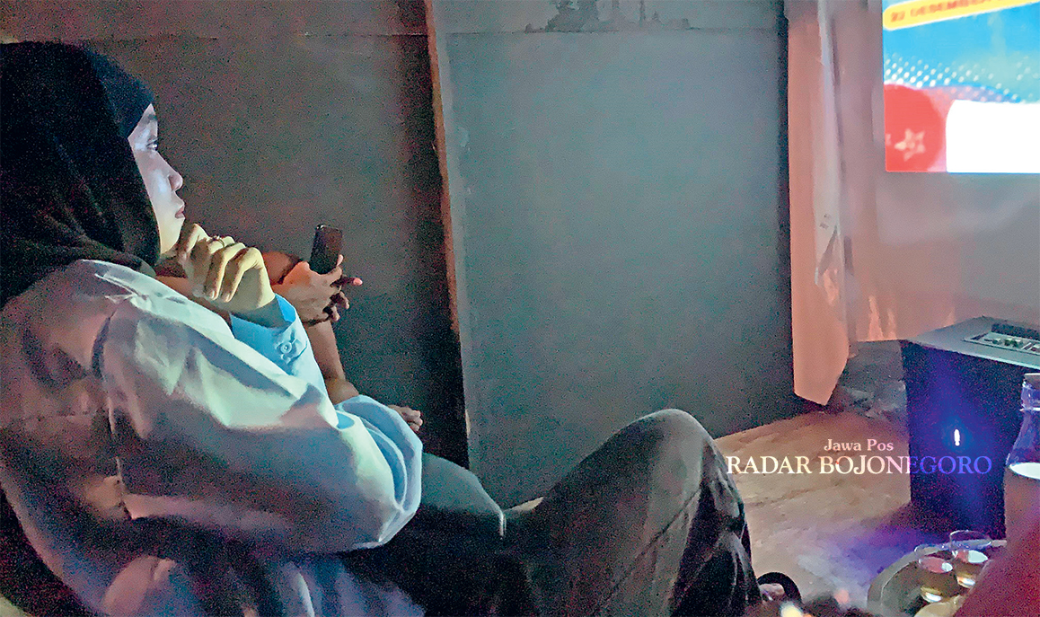 NONTON: Ana bersama temannya sedang fokus menonton film berjudul Bait Terakhir karya Krisna Bayu di dalam Bios Box berukuran 2x2 meter. (RAHUL OSCARRA DUTA/RADAR BLORA)