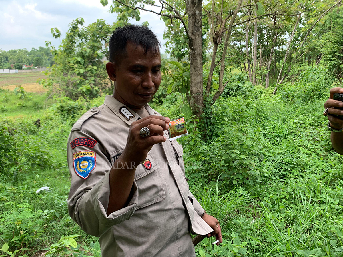MIRIS: Bhabinkamtibmas Kelurahan Kunden Bripka Teguh Waluyo menunjukkan bungkus obat kuat yang ia temukan di sisi selatan eks lapangan golf.  (RAHUL OSCARRA DUTA/RADAR BLORA)