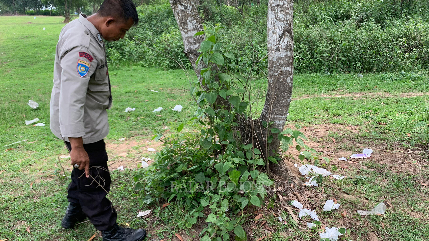 TIDAK TERAWAT: Bhabinkamtibmas Kelurahan Kunden Bripka Teguh Waluyo saat sidak ke lokasi eks lapangan golf. Banyak bungkus alat kontrasepsi, tisu magic, dan jamu kuat berceceran. (RAHUL O./RDR.BJN)