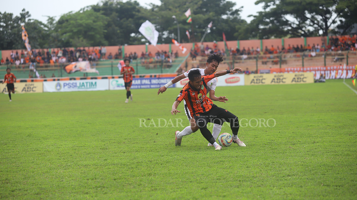 WASPADA: Roni Rosadi melindungi bola dari pemain Pessu pada pertadingan perdana grup MM Minggu (28/1) lalu. menghadapi PSM Madiun (YUAN EDO/RADAR BOJONEGORO)