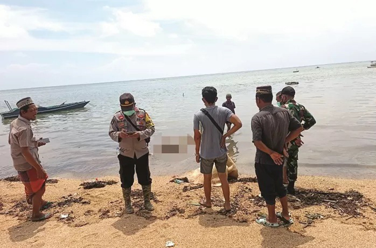 TIDAK BERNYAWA: Warga bersama kepolisian mengevakuasi mayat Zainal Abidin, ABK KMN Putra Sumber Mas, di pesisir pantai Dusun Saghubing, Desa Buddhi, Kecamatan Arjasa, Sumenep. (RADAR MADURA/RDR.LMG)