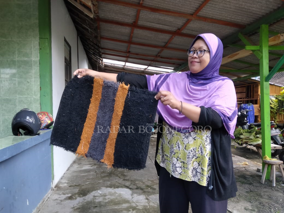 TERTIPU: Atik Muryanti jadi korban penipuan. Ia menunjukkan keset yang dikirim oleh pihak toko online. Padahal ia pesan baju gamis dari toko tersebut. (LUKMAN HAKIM/RADAR BLORA)