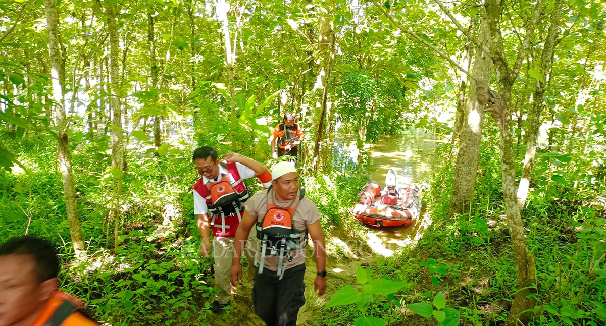 BERJIBAKU : Petugas Damkar dan Satpol PP mengevakuasi warga terisolir di pinggir hutan yang terdampak banjir. (LUKMAN HAKIM/RADAR BOJONEGORO)