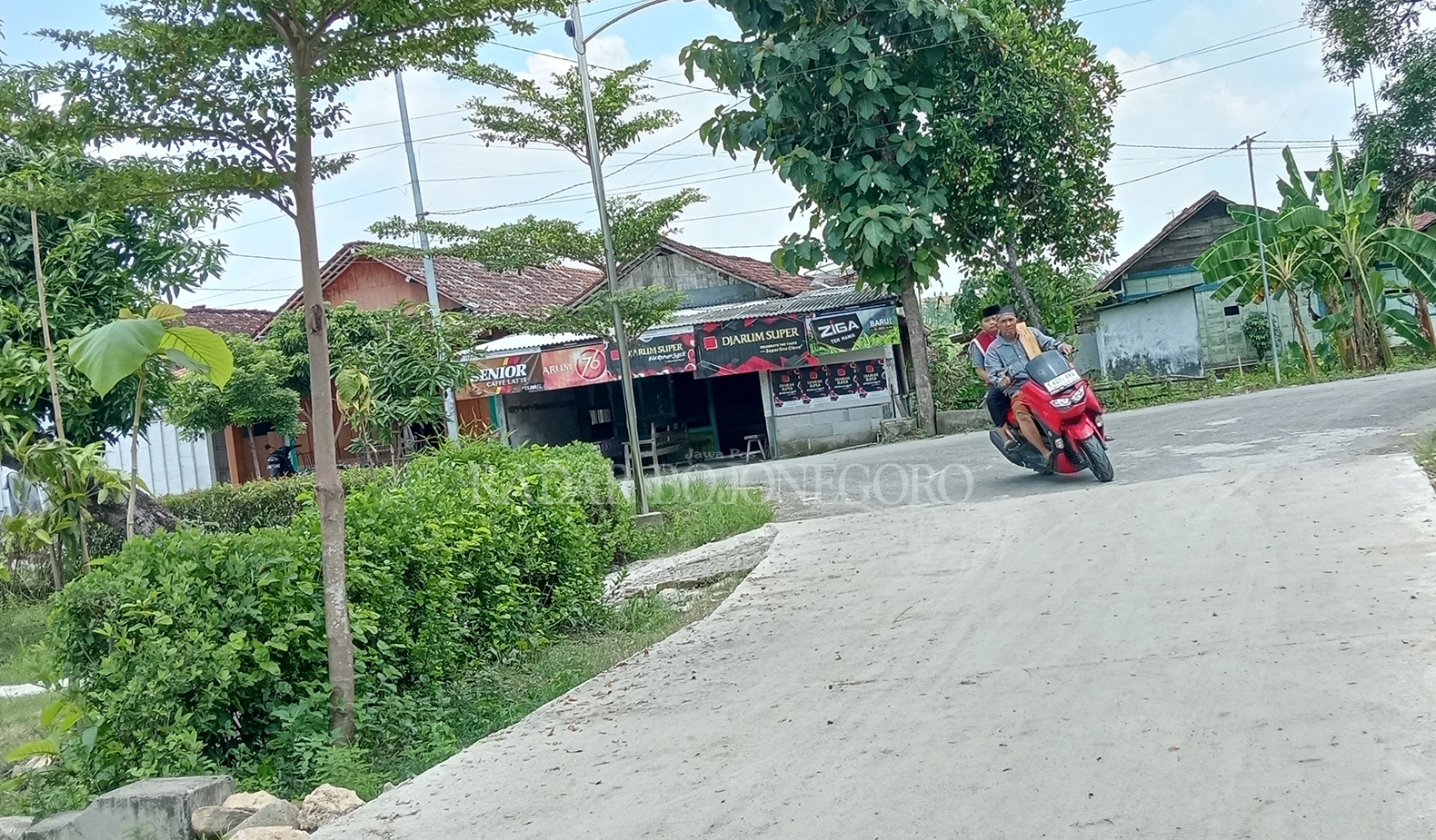 MULUS: Warga melintas di Jalan Raya Ngambong yang sudah mulus. (YANA DWI KURNIAWATI/RDR.BJN)
