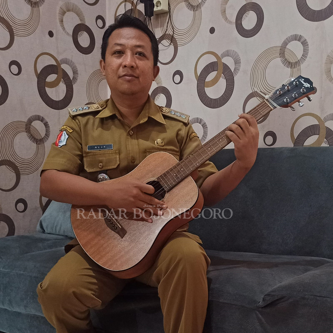 BAWA GITAR: Alit sedang memainkan gitar, darah seni mengalir dari orang tuanya. (DEWI SAFITRI/RADAR BOJONEGORO)
