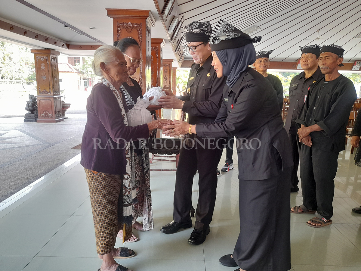 SIMBOLIS: Pj Bupati Bojonegoro Adriyanto didampingi Sekda Pemkab Bojonegoro Nurul Azizah menyerahkan tanah makam Samin Surosentiko kepada ahli waris Samin di Pendapa Malowopati Selasa (20/2).
