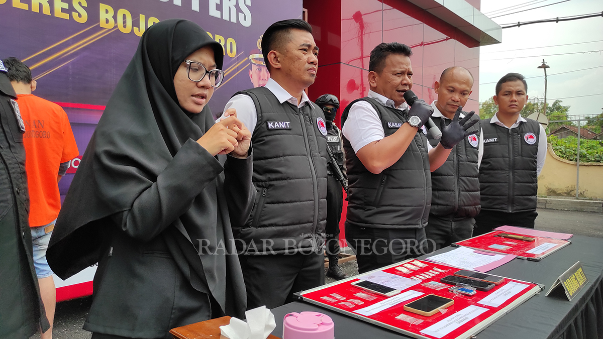TEKUN: Asna menerjemahkan ucapan Kasatreskoba Polres Bojonegoro AKP Eko Suwanto (pegang mikrofon) saat konferensi pers di halaman Mapolres Bojonegoro (WAHYU DHANI ALFIANSYAH/RADAR BOJONEGORO)