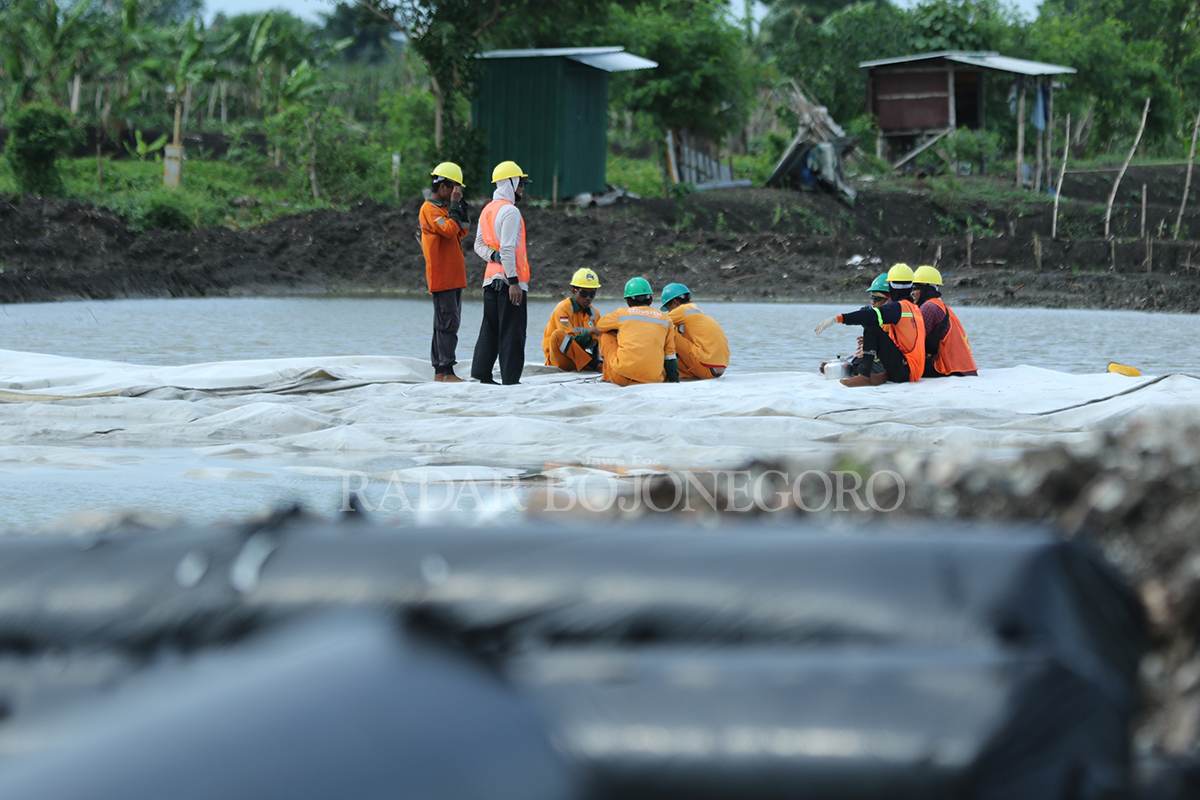 TAHAP AWAL: Petugas memasang lapisan geotekstil di JLU sesi satu di Desa Rejosari, Kecamatan Deket.  (ANJAR DWI PRADIPTA/RDR.LMG )
