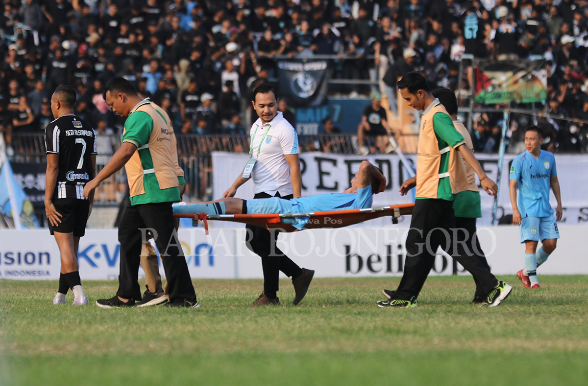 SENANG JADI BAGIAN PERSELA: Pemain Persela yang cedera di tengah lapangan mendapatkan penanganan dari dr Tsalis Fithrony. (ANJAR DWI PRADIPTA/RDR.LMG)