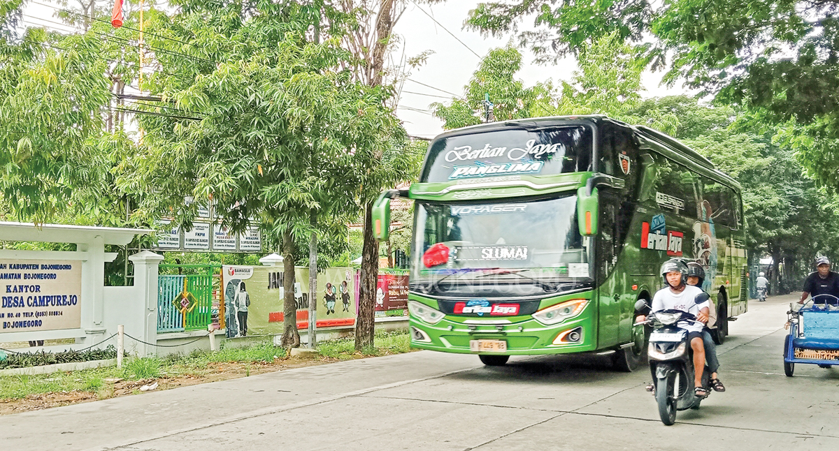 BELUM CAIR: Tampak lalu lalang kendaraan di Jalan Lisman depan Balai Desa Campurejo, Kecamatan Bojonegoro Kota. Salah satu desa belum mengajukan pencairan ADD. (YANA DWI K/RDR.BJN)