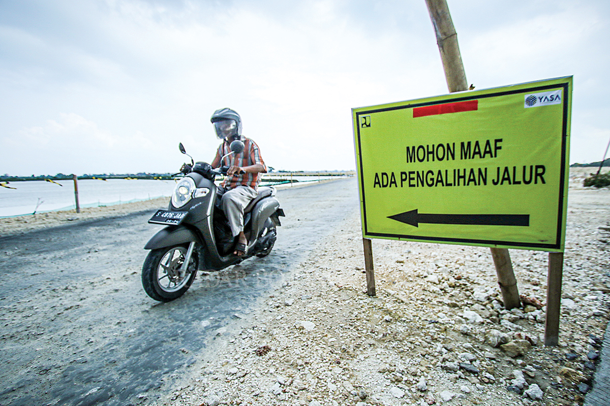 HARAPKAN BAWA MULTIEFEK: Jalan Lingkar Utara Lamongan yang masih pemadatan material dilewati kendaraan roda dua. (ANJAR DWI PRADIPTA/RDR.LMG)