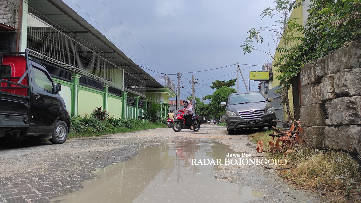 TERGANJAL STATUS LAHAN: Jalan Ponpin Bojonegoro ini kondisinya rusak. Perbaikan jalan tergantung izin dari PT KAI. (DHANI WAHYU ALFIANSYAH/RADAR BOJONEGORO)