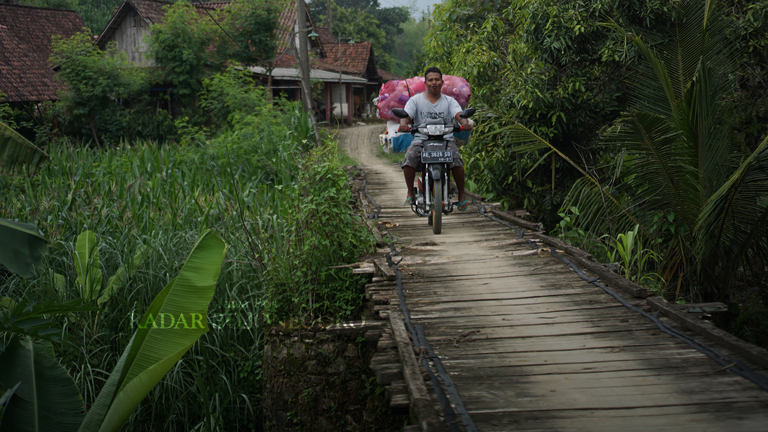 MELINTAS JEMBATAN TUA: Warga Desa Bobol, Kecamatan Sekar melintasi jembatan tua peninggalan Belanda. (HAKAM ALGHIVARI/RADAR BOJONEGORO)