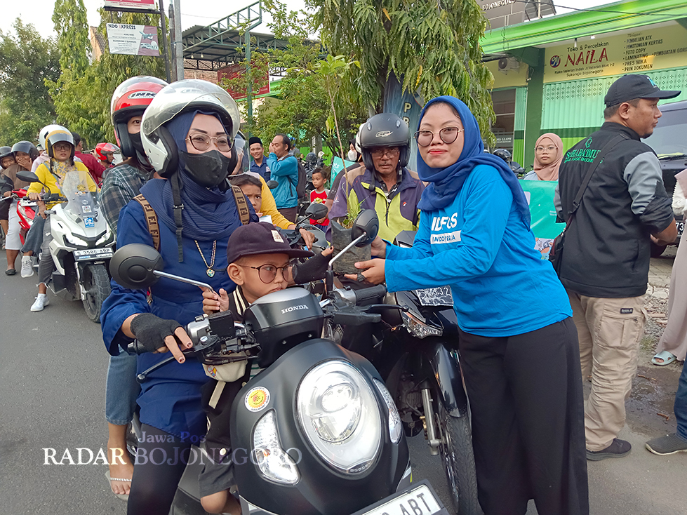 PEDULI LINGKUNGAN: Aktivis lingkungan bagikan pohon kepada pengguna jalan Bojonegoro kemarin (30/3). (ISTIMEWA/RADAR BOJONEGORO)