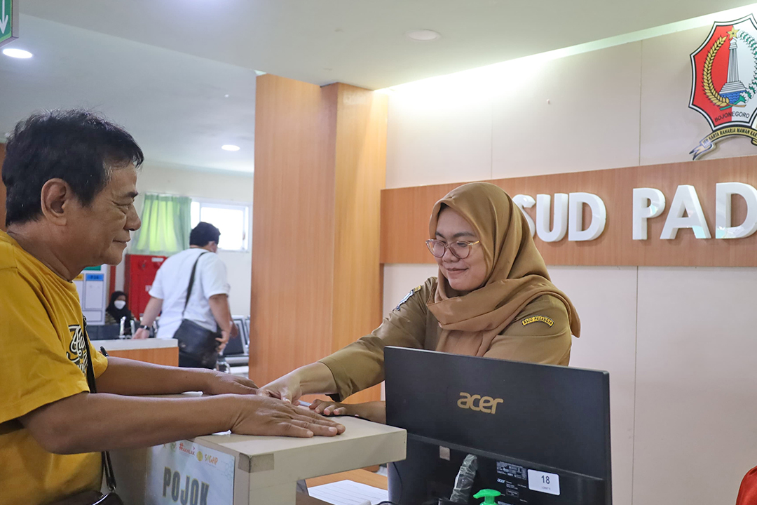 PELAYANAN: Petugas RSUD Padangan sedang membantu pasien yang mendaftar online melalui Mobile JKN untuk melakukan sidik jari