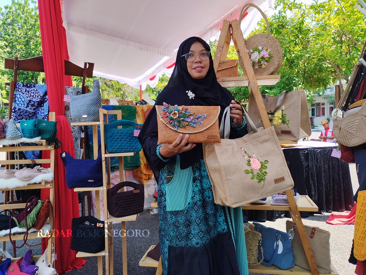 KREATIF: Meirina Suminartyaningsih memamerkan beberapa buah karya kerajina tangannya berupa tas dan dompet. (HAKAM ALGHIVARI/RADAR BOJONEGORO)