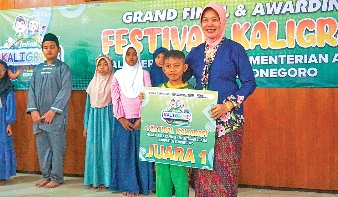 JUARA SATU: Firza Nawarul foto bersama Sekda Bojonegoro Nurul Azizah saat penerimaan hadiah Juara 1 Festival Kaligrafi Piala Kepala Kantor Kemenag Bojonegoro 2024.