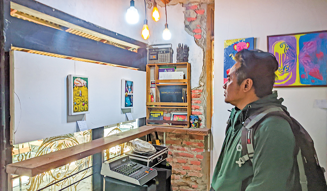 PAMER KARYA: Dhadang SB, Koordinator Drawing Desa menunjukkan beberapa karya seniman di Bojonegoro Art Exhibition.