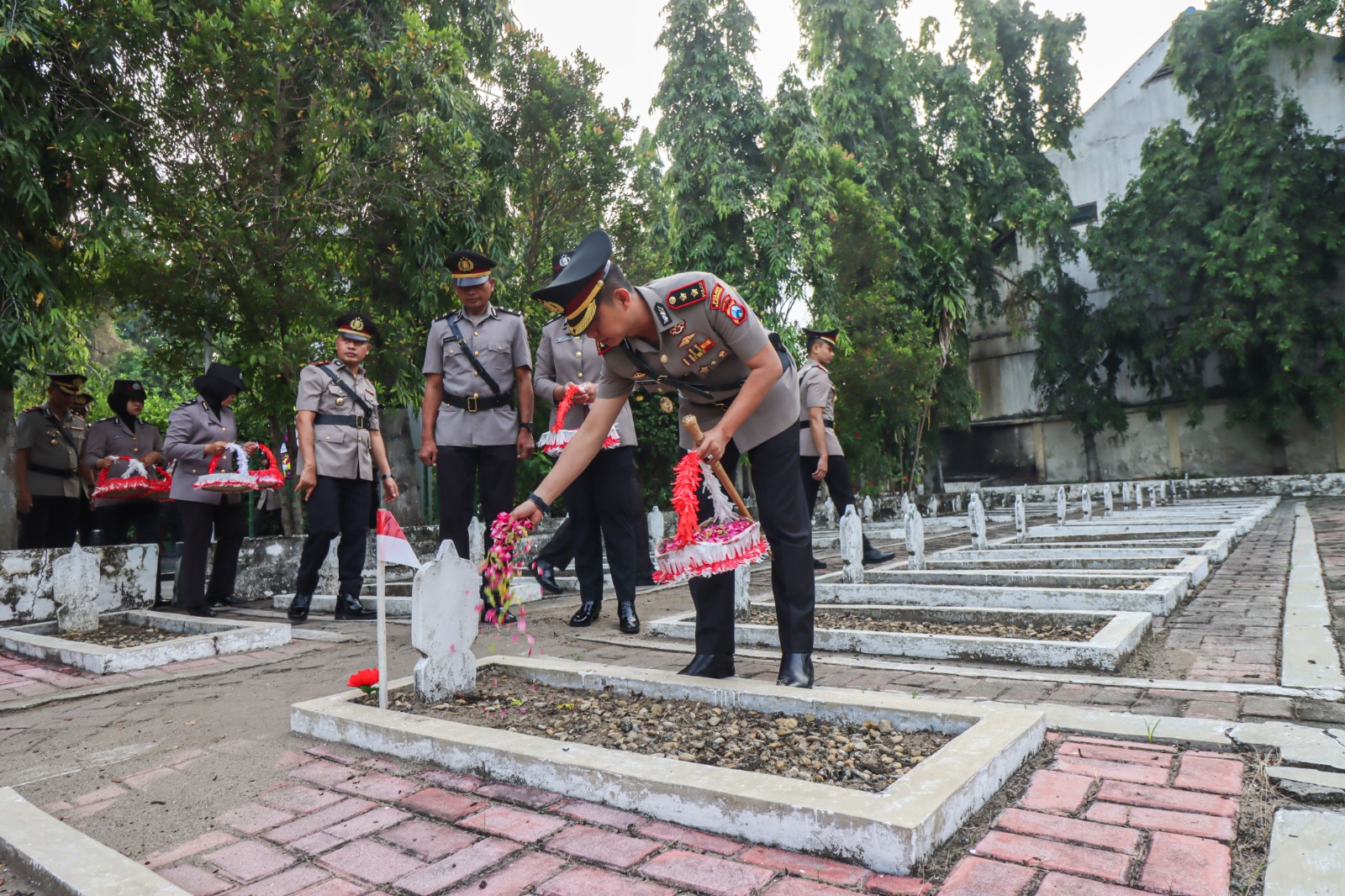 TABUR BUNGA: Kapolres Bojonegoro AKBP Mario Prahatinto saat menaburkan bunga ke pusara di Taman Makam Pahlawan (24/6).
