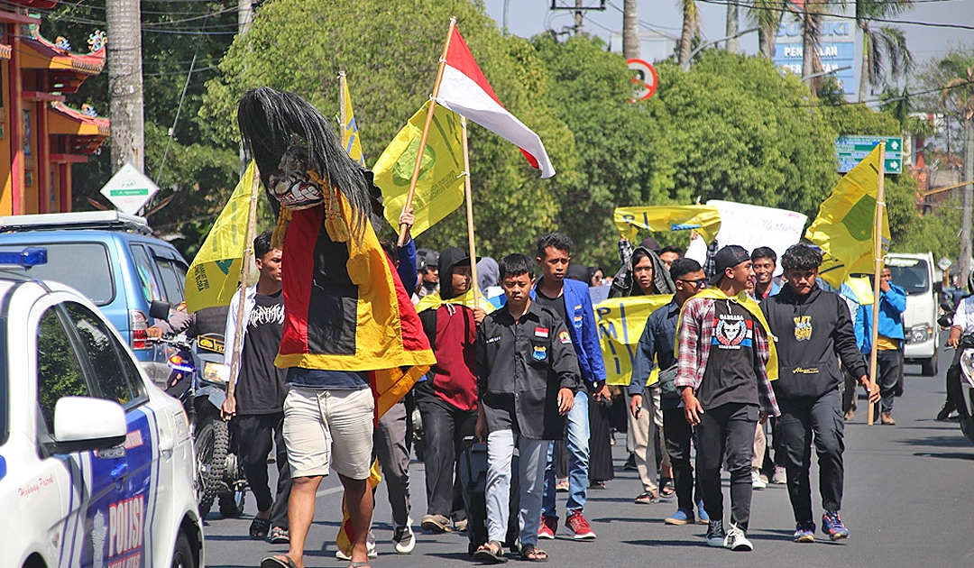 Belasan Mahasiswa PMII Blora menggelar long march di tengah Kota Blora.