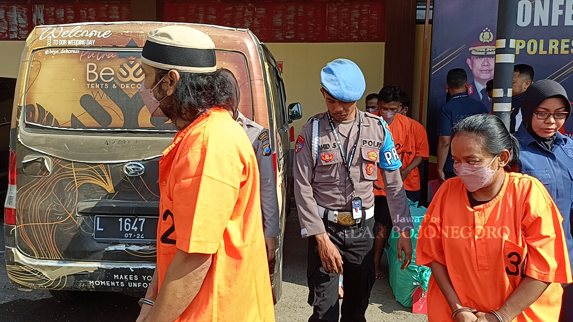MIRAS MAUT: Tersangka pria berinisial M (berpeci) selaku pemasok miras dan tersangka perempuan berinisial W selaku pemilik kafe di Desa Sidobandung, Kecamatan Balen. (YUAN EDO/RADAR BOJONEGORO)