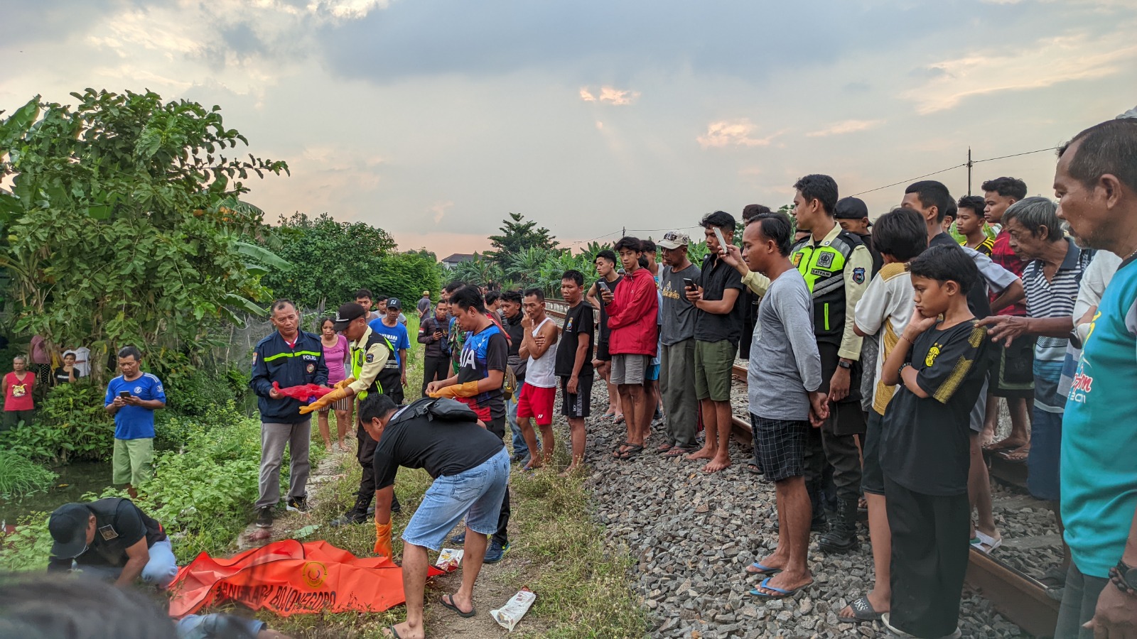EVAKUASI: Petugas kepolisian melakukan olah TKP sekaligus evakuasi jasad korban kecelakaan kereta api turut Kelurahan Sumbang kemarin (7/7). (WAHYU DHANI ALFIANSYAH/RADAR BOJONEGORO)