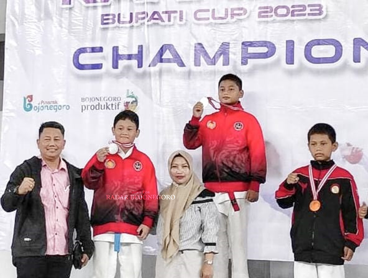 BANGGA: Zainal Arifin (paling kiri) langganan mengantarkan anak didiknya menjuarai kompetisi karate. (ISTIMEWA/RADAR BOJONEGORO)