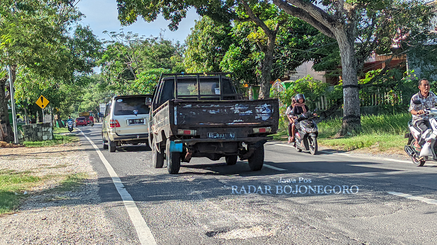 BERLUBANG: Jalan Bojonegoro-Dander kondisinya berlubang dan bergelombang. Jalan sepanjang 10 kilometer itu menjadi akses menuju tiga objek wisata unggulan Bojonegoro. (DHANI WAHYU ALFIANSYAH/RADAR BOJ