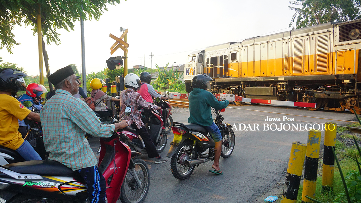 RAWAN LAKA: Pengendara berhenti di perlintasan rel kereta api. Setelah kejadian bocah 11 tahun tewas karena tertabrak saat bermain layang-layang di Kelurahan Sumbang, Kecamatan Kota, pada Minggu (7/7)