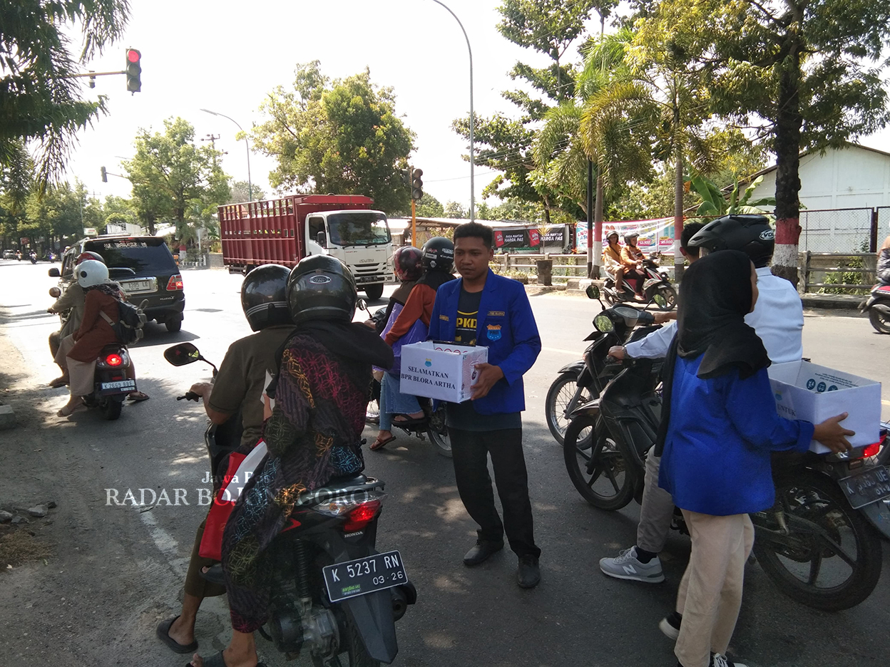 KRITIK: Mahasiswa Blora sampaikan kritik atas kasus kredit macet BPR Bank Blora Artha dengan menggalang koin di Jalan Ahmad Yani kemarin (10/7). (LUKMAN HAKIM/RADAR BOJONEGORO)