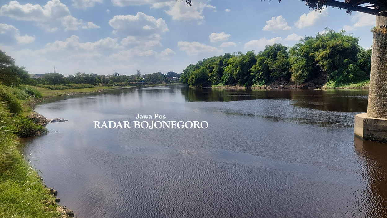 AIR BERUBAH WARNA: Kondisi warna air Bengawan Solo tampak berubah warna merah kehitaman. Warga menduga pencemaran akibat limbah pabrik. (LUKMAN HAKIM/RADAR BOJONEGORO)