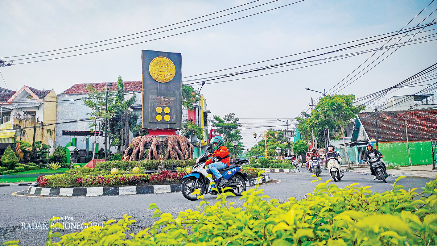 PAKAI JAKET: Pengendara motor saat melintas di Bundaran Adipura Bojonegoro mengenakan jaket. Sepekan terakhir suhu udara di Bojonegoro saat malam 19 derajat celcius.