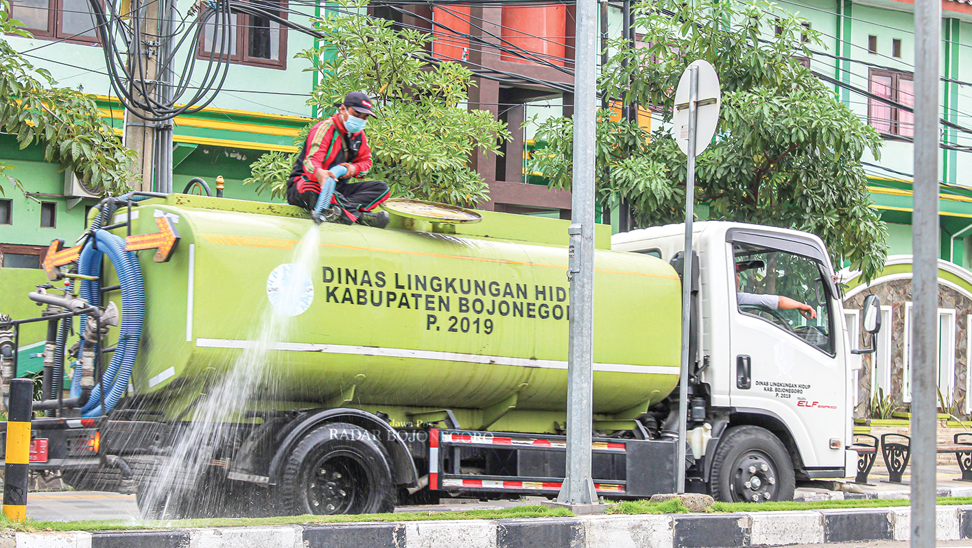 SIRAM TANAMAN: Petugas menyiram tenaman di taman sepanjang jalan protokol Bojonegoro, agar tidak kering saat musim kemarau.