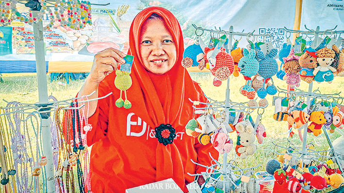 HASIL RAJUTAN SENDIRI: Sumarni menunjukkan salah satu kerajinan rajutnya.