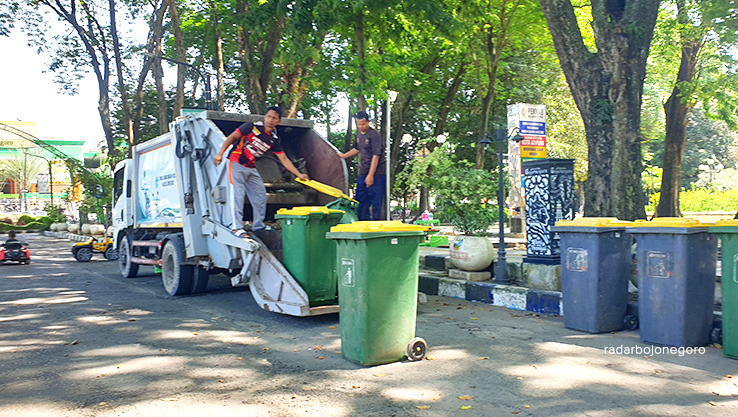 ANGKUT SAMPAH: Petugas DLH Bojonegoro mengangkut sampah di area Alun-Alun Bojonegoro. (HAKAM ALGHIVARI/RADAR BOJONEGORO)
