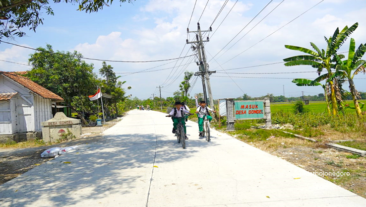 JALAN MULUS: Siswa-siswi sedang berangkat ke sekolah saat ini bisa menikmati akses jalan mulus jurusan Gondel-Ketuwan-Mojorembun. (ISTIMEWA/RADAR BOJONEGORO)