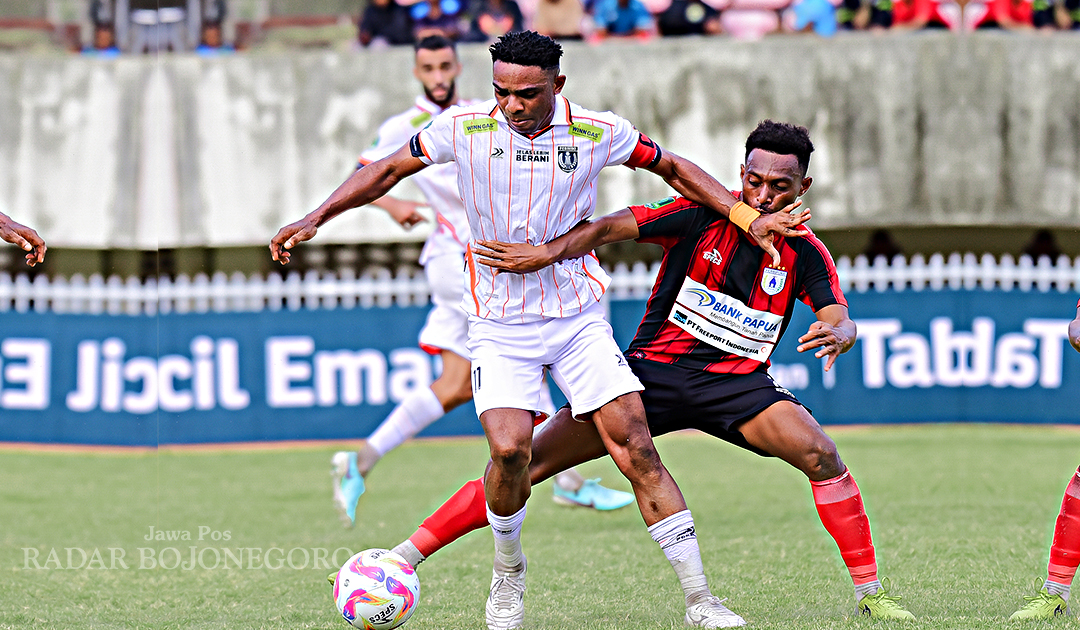 TIM MEDIA OFFICER PERSIBO FOR RADAR BOJONEGORO BEREBUT BOLA: Sang kapten Persibo Osas Saha sedang fokus menjaga bola dari hadangan pemain Persipura Jayapura saat laga tandang di Stadion Mandala
