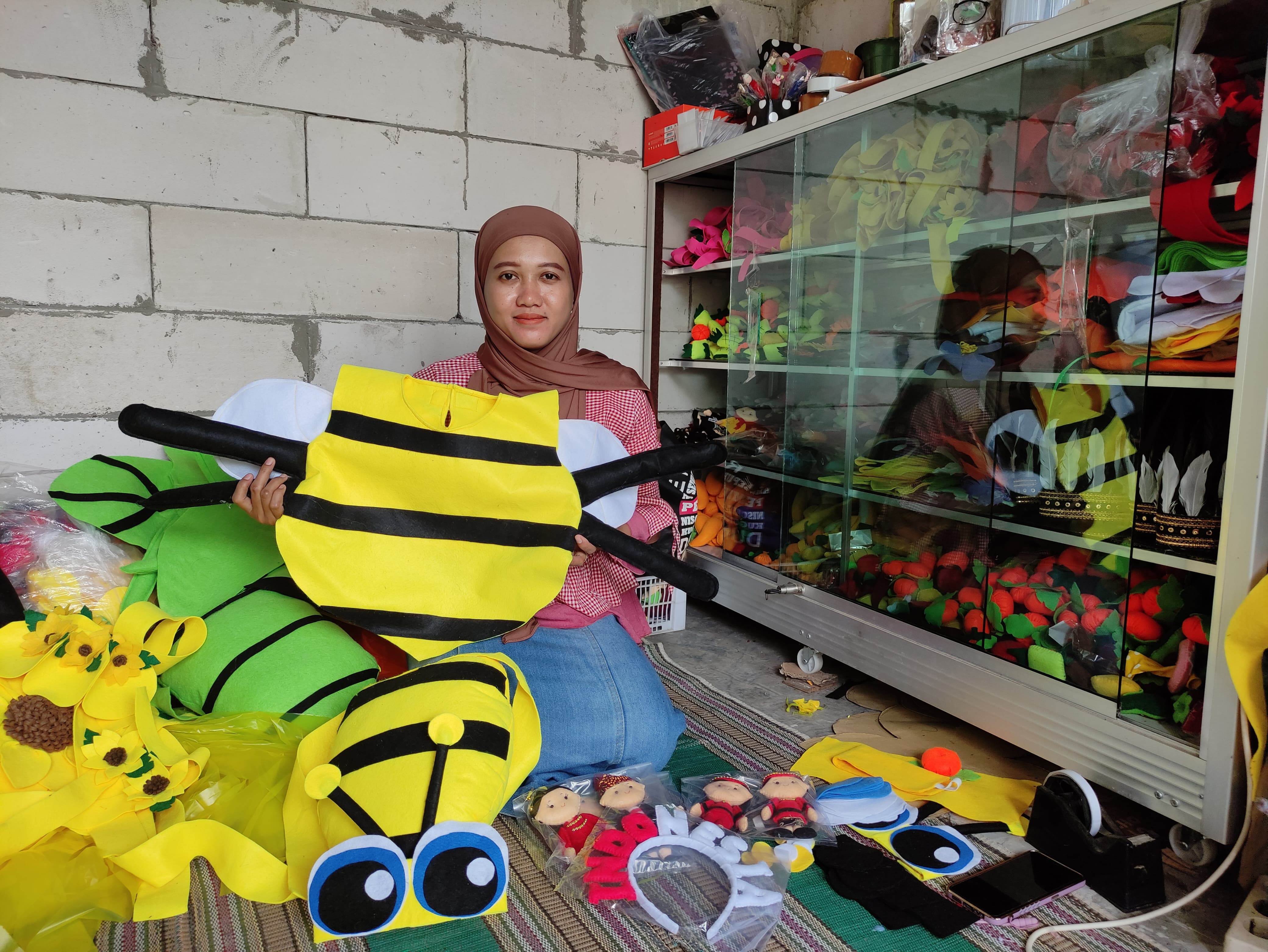 KREATIF: Titis Setyowati pamerkan kostum aneka satwa berbahan kain flannel. Kerajinannya laris manis dijual di Shopee. (AHMAD NAWAF TIMYATI FANDAWAN/RADAR BOJONEGORO)