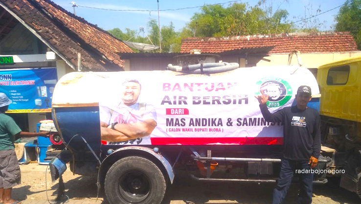 AIR BERSIH: Truk tangki air bersih dipasang banner foto Cawabup 02 dan logo Saminista saat dropping di Desa Tutup.