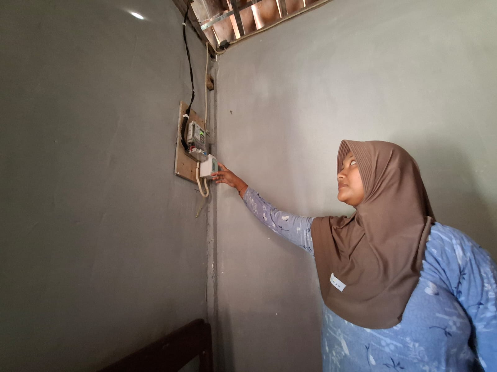 Penerima bantuan subsidi dan pemasangan listrik gratis di Kecamatan Temayang menunjukkan instalasi listrik di rumahnya. (HAKAM ALGHIVARI/RADAR BOJONEGORO)