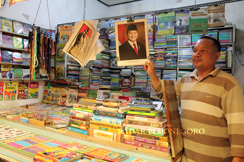 FOTO PRESIDEN: Para pengusaha toko buku di Pasar Kota Bojonegoro mulai menjual foto Presiden dan Wakil Presiden 2024-2029 terpilih. (DHANI WAHYU ALFIANSYAH/RADAR BOJONEGORO