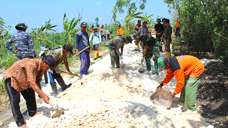 JALAN MULUS: Para TNI bersama warga Desa Sidomulyo, Kecamatan Banjarejo dalam program TMMD Reguler ke-122 bergotong royong memperbaiki jalan yang rusak. (RAHUL OSCARRA DUTA/RADAR BOJONEGORO)
