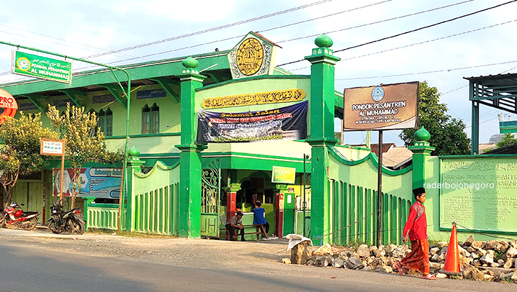 PONDOK PESANTREN: Seorang santri mengenakan setelan baju koko merah, sarung merah, dan peci hitam sedang berjalan keluar dari Pondok Pesantran Al Muhammad turut Kecamatan cepu.