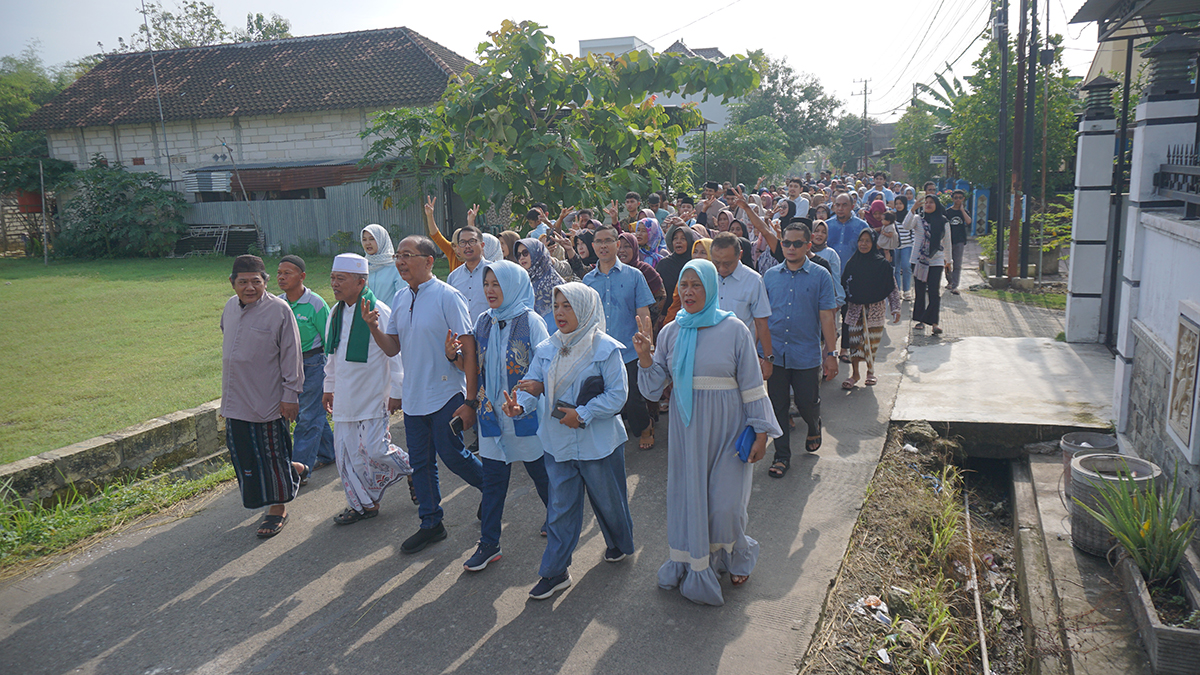 Cawabup Nomor 02 Nurul Azizah (Depan, nomer empat dari kiri) dan keluarga dikawal kyai dan warga Desa Sumbertlaseh, Kecamatan Dander menuju TPS (27/11). (HAKAM ALGHIVARI/RADAR BOJONEGORO)