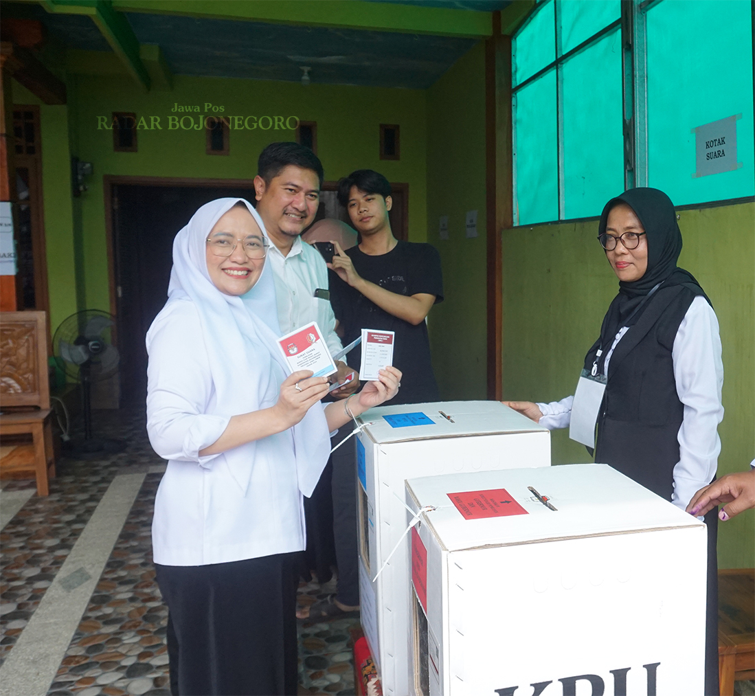 DIDAMPINGI SUAMI: Cawabup nomor 01 Farida Hidayati menggunakan hak pilihnya di TPS 14 Kelurahan Ledok Kulon kemarin. (YUAN EDO/RADAR BOJONEGORO)
