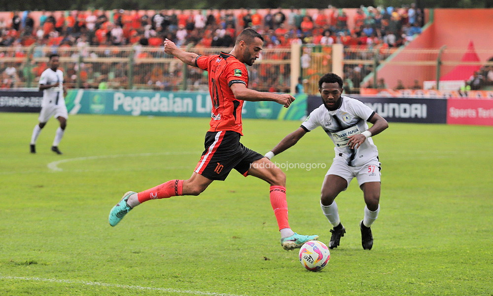 POIN MELAYANG: Striker Persibo Enzo Celestine diadang bek Persipura Urbanus Lasol saat hendak melesatkan bola ke gawang Persipura di SLS Bojonegoro, Minggu (1/12).