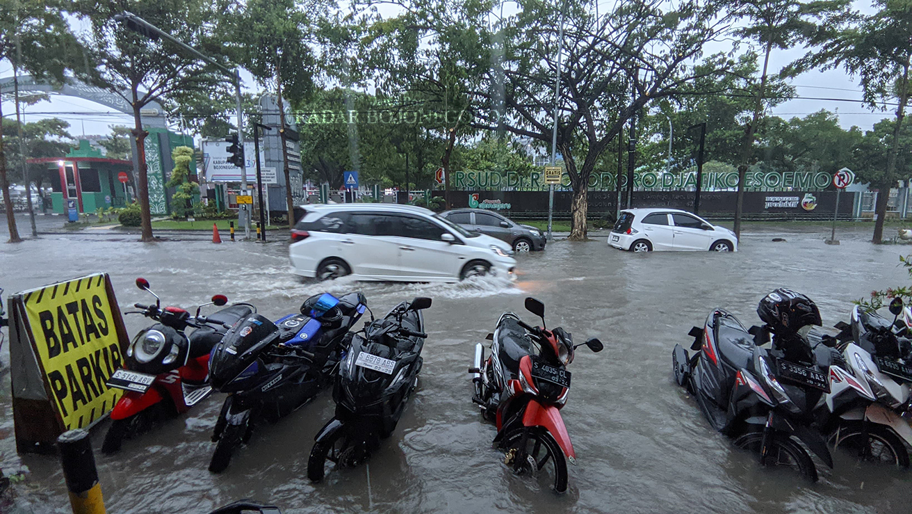 TERGENANG: Jalan Veteran tepatnya di depan RSUD Sosodoro Djatikoesoemo Bojonegoro tergenang air. Kondisi ini sudah menjadi langganan setiap turun hujan. Butuh solusi jangka panjang. (DHANI WAHYU ALFIA