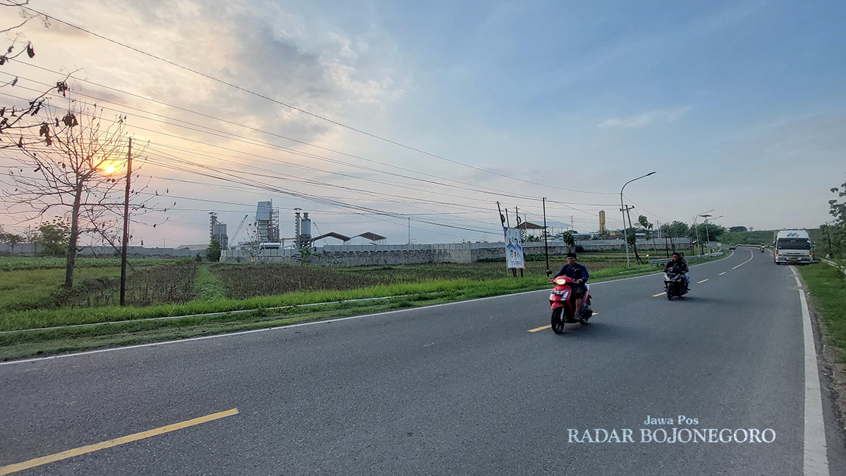 INVESTASI: Lahan kawasan industri di selatan ruas Jalan Cepu-Blora di Kecamatan Sambong telah berdiri pabrik pengolahan jagung, tampak pengendara sepeda motor melintas. (M. LUKMAN HAKIM/RADAR BOJONEGO